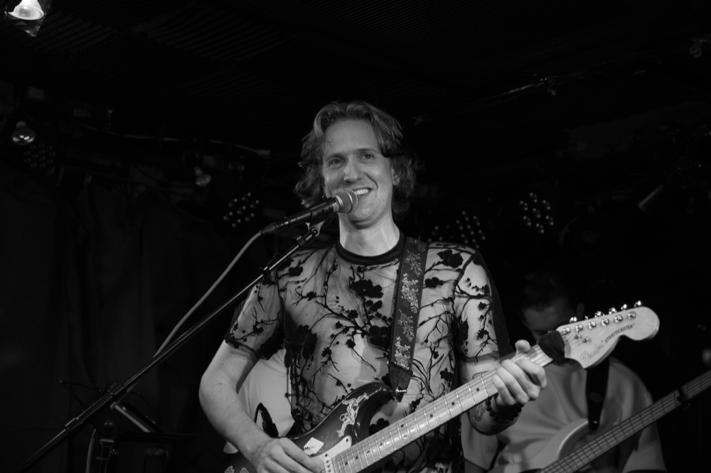 Moanzy smiling mid-song, black and white