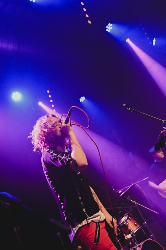 Moanzy performing live under purple stage light